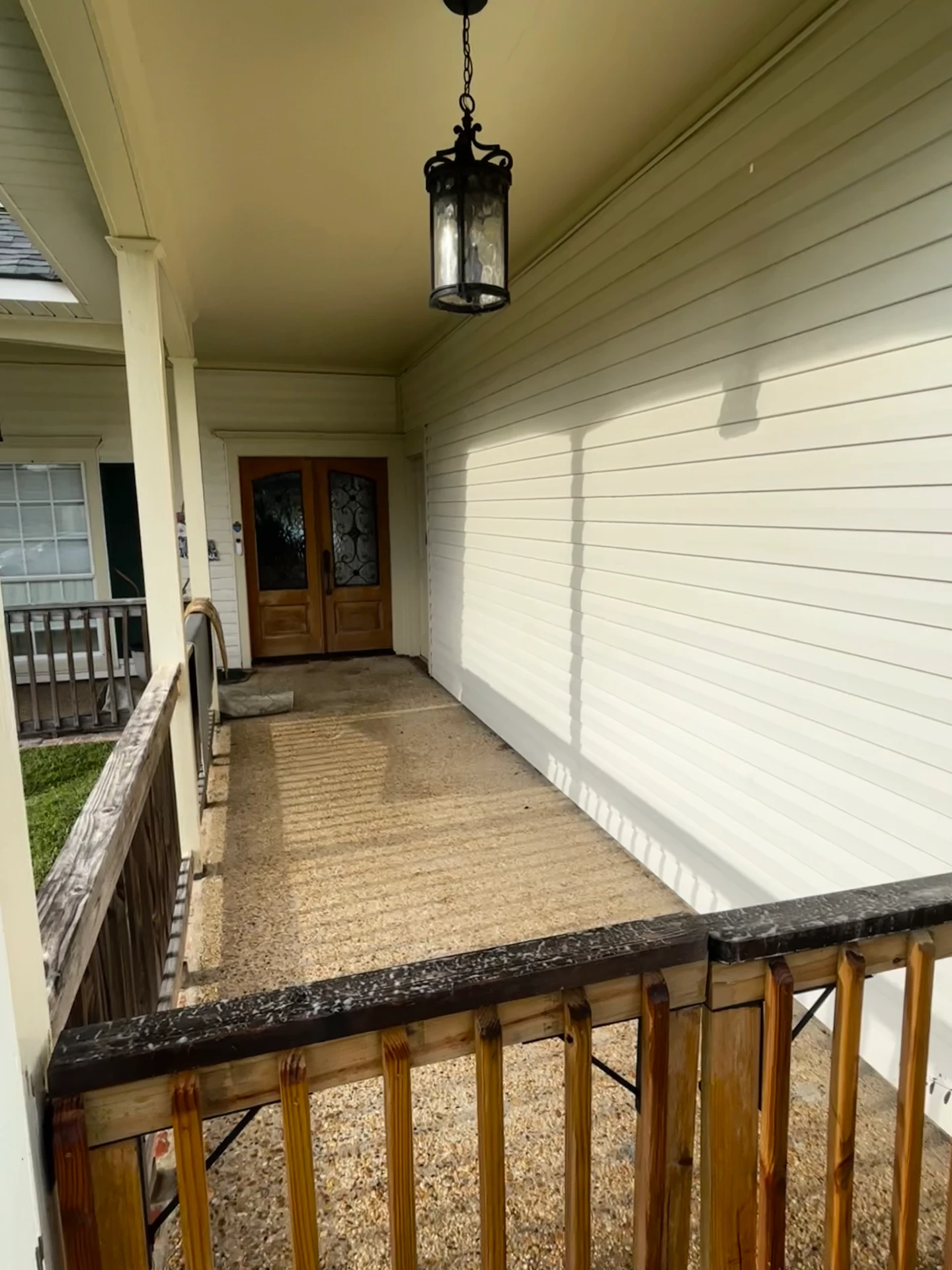 White siding between green shutters after cleaning