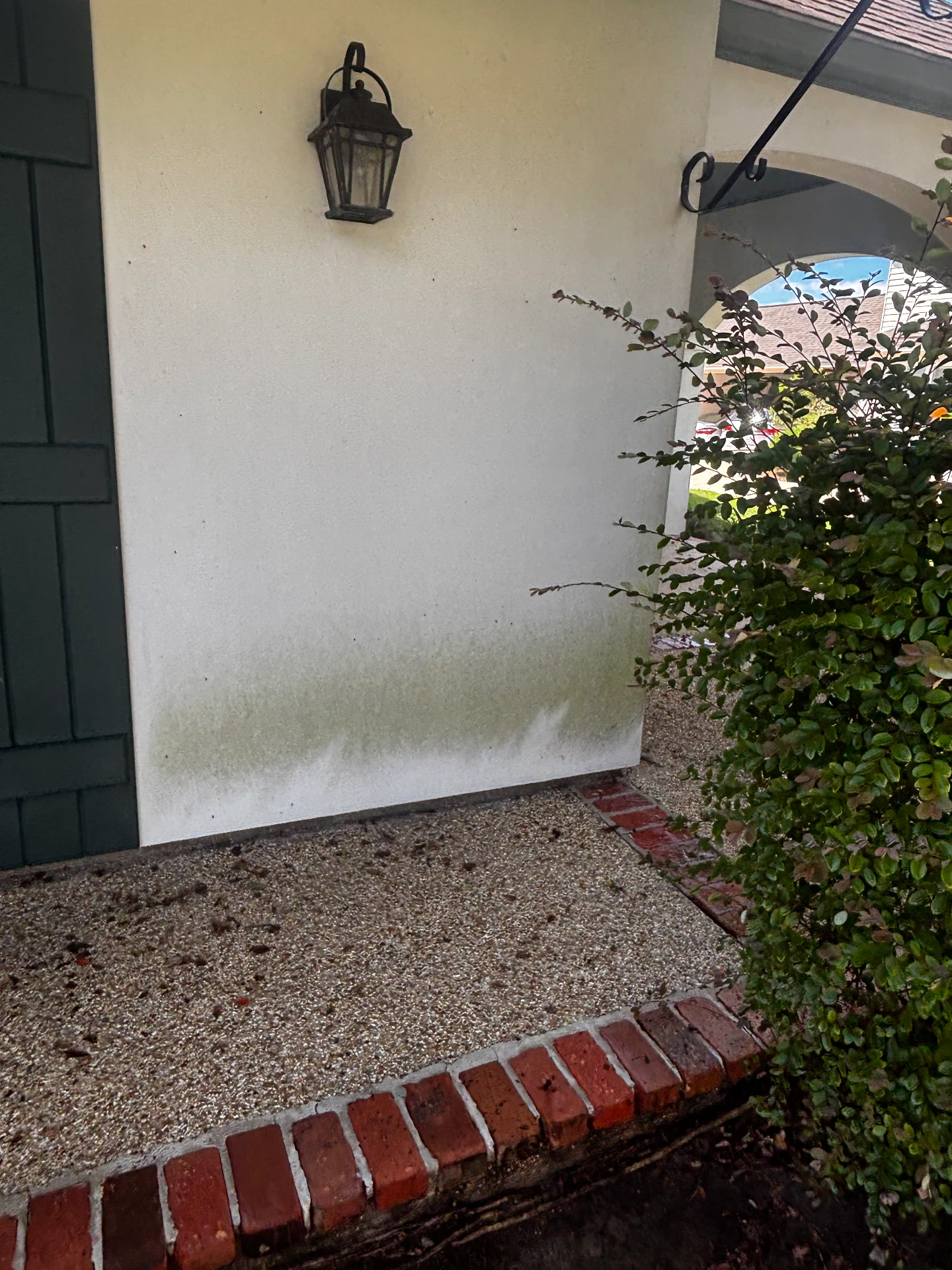 Stucco entrance wall by the lantern before cleaning