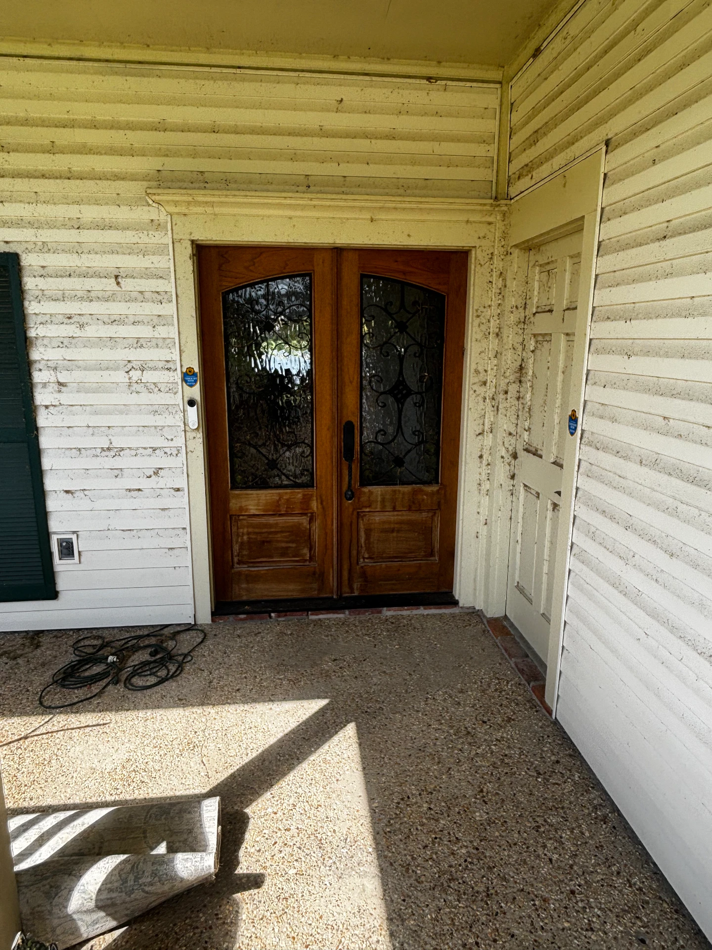 Front porch with wood doors before cleaning